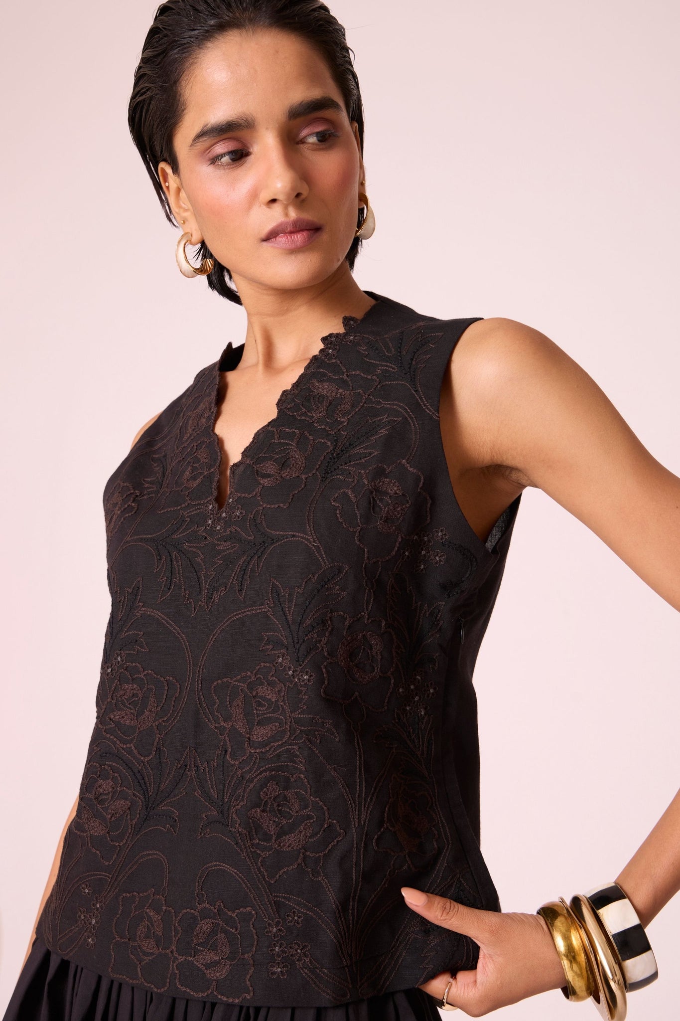 Black linen-cotton sleeveless top with hand-embroidered bodice, V-neckline, and side zip fastening.