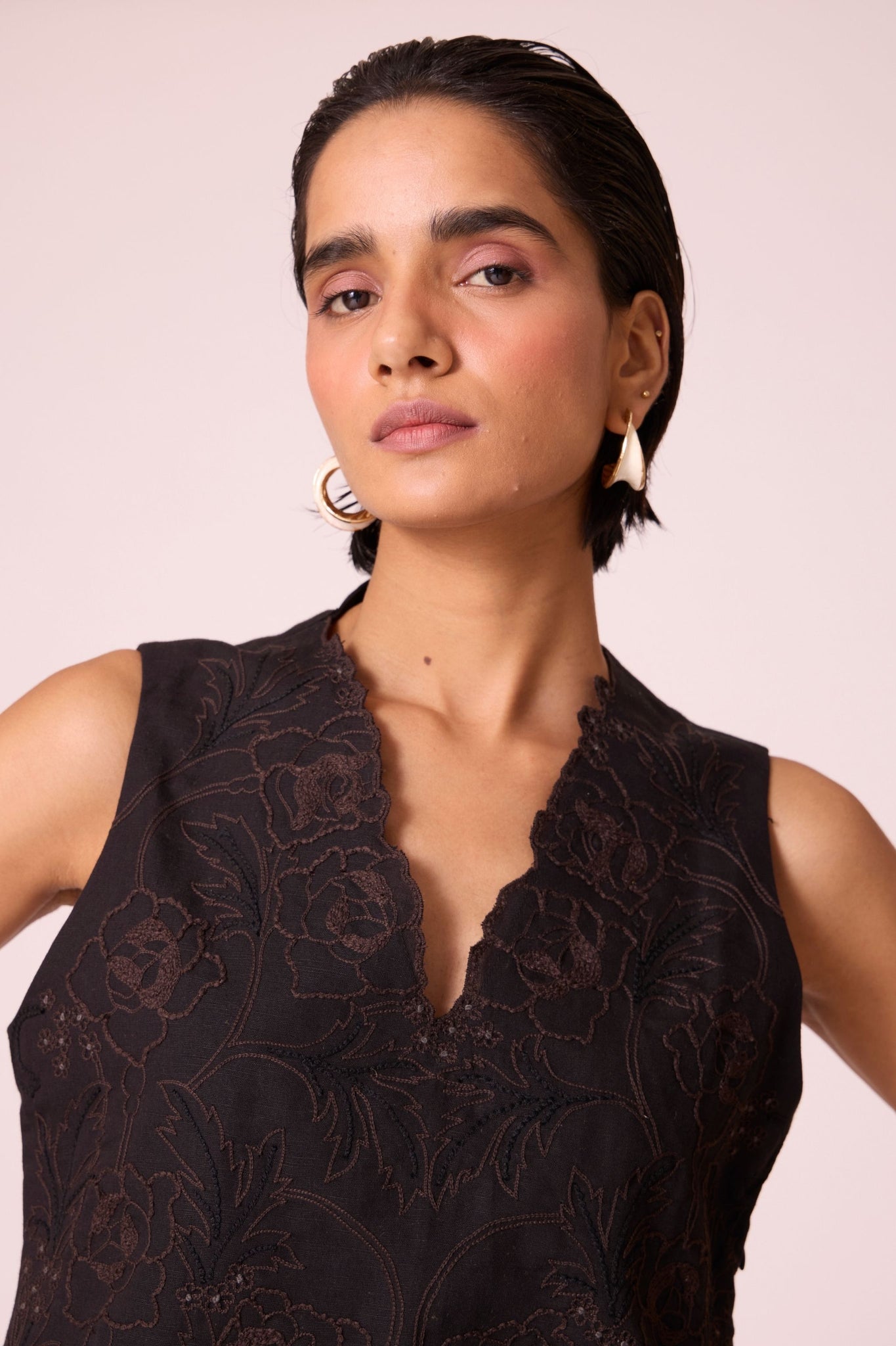 Black linen-cotton sleeveless top with hand-embroidered bodice, V-neckline, and side zip fastening.