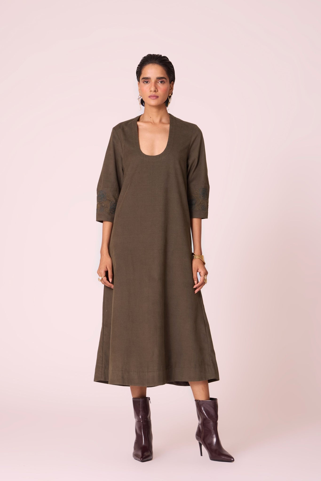 Olive needlecord A-line dress with drop shoulder, hand-embroidered cuff, deep scoop neckline, and in-seam pockets.