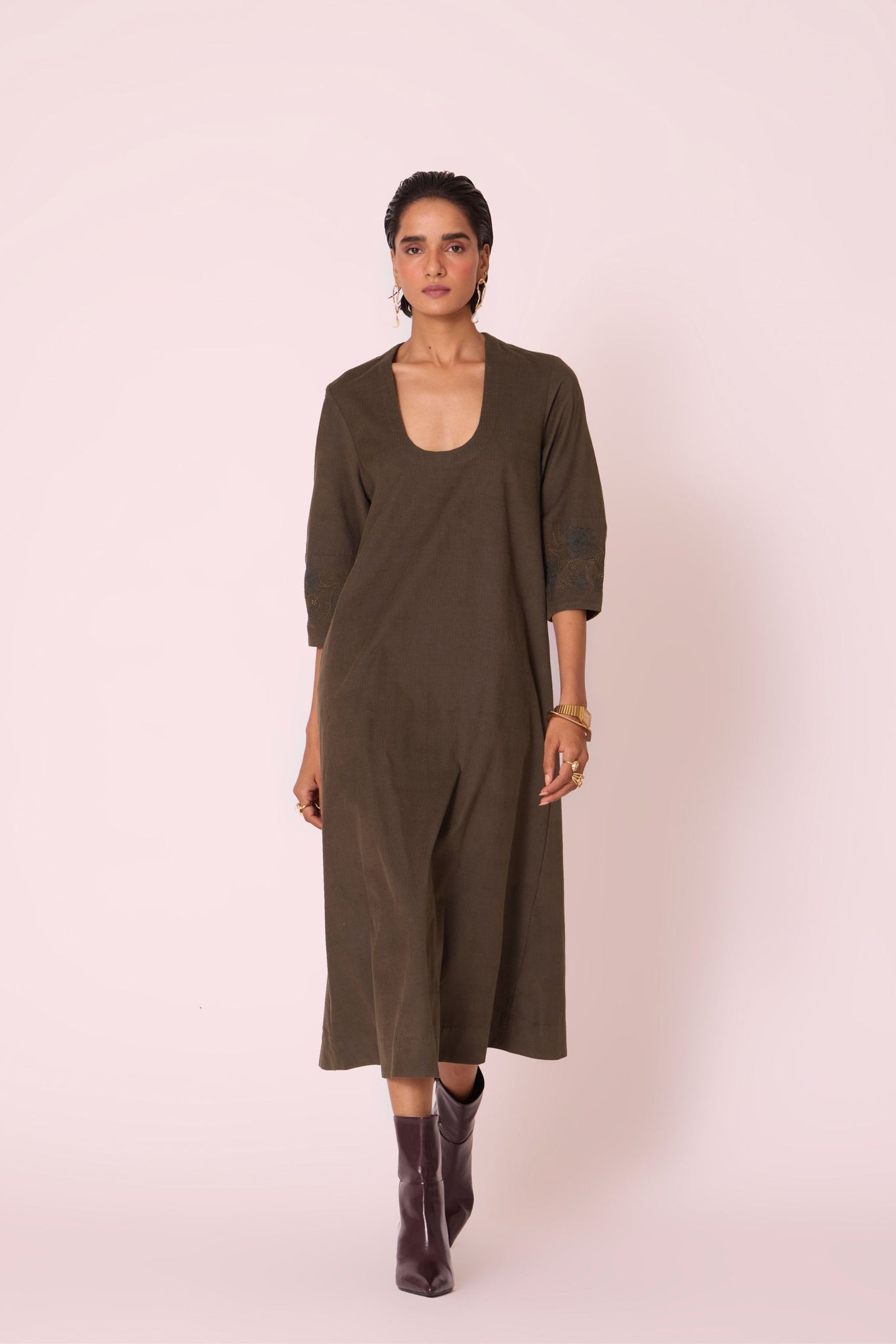 Olive needlecord A-line dress with drop shoulder, hand-embroidered cuff, deep scoop neckline, and in-seam pockets.
