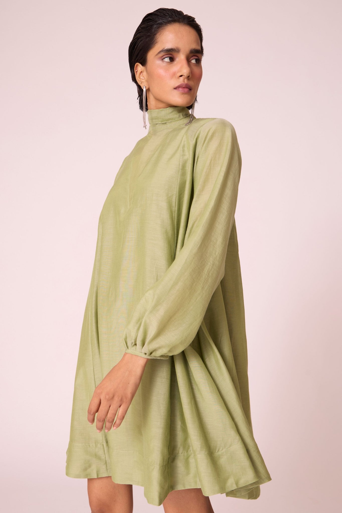 Green silk-cotton panelled short dress with halter neck, back tie, bishop sleeves, and lined body.