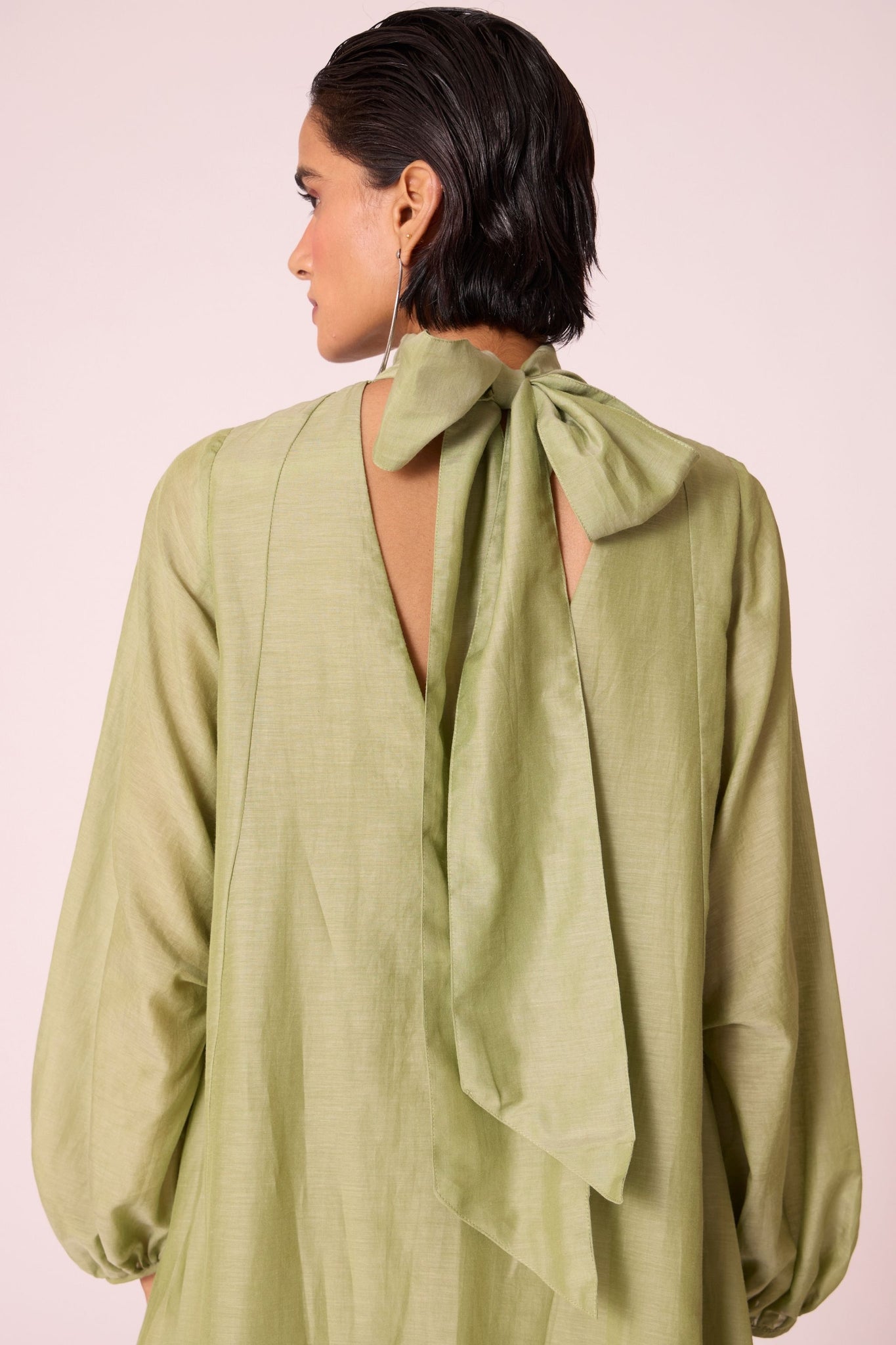 Green silk-cotton panelled short dress with halter neck, back tie, bishop sleeves, and lined body.