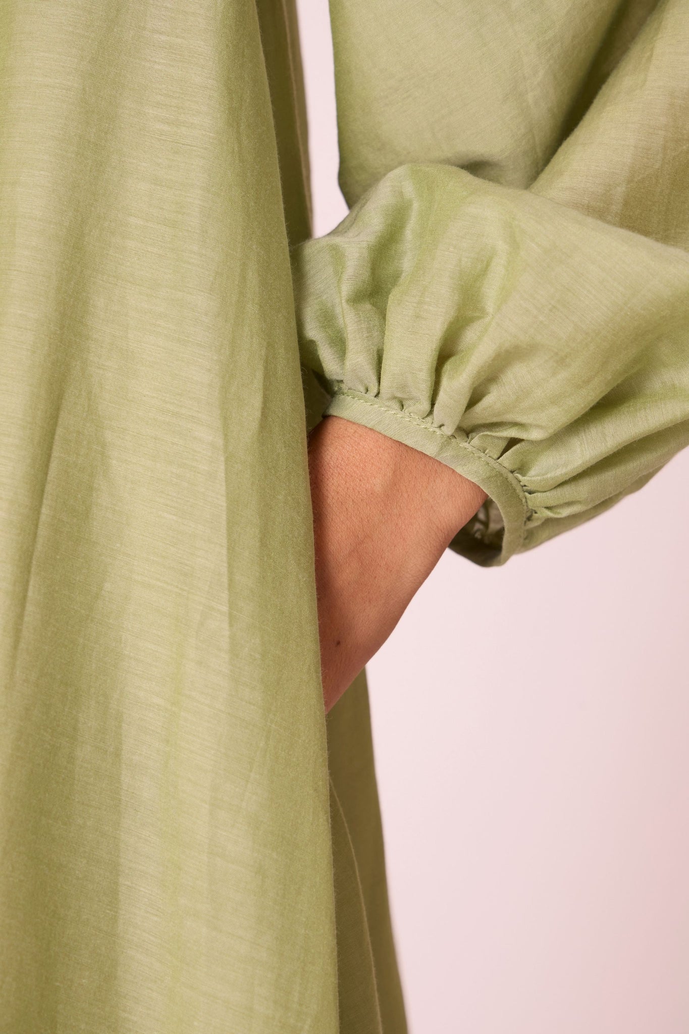 Green silk-cotton panelled short dress with halter neck, back tie, bishop sleeves, and lined body.