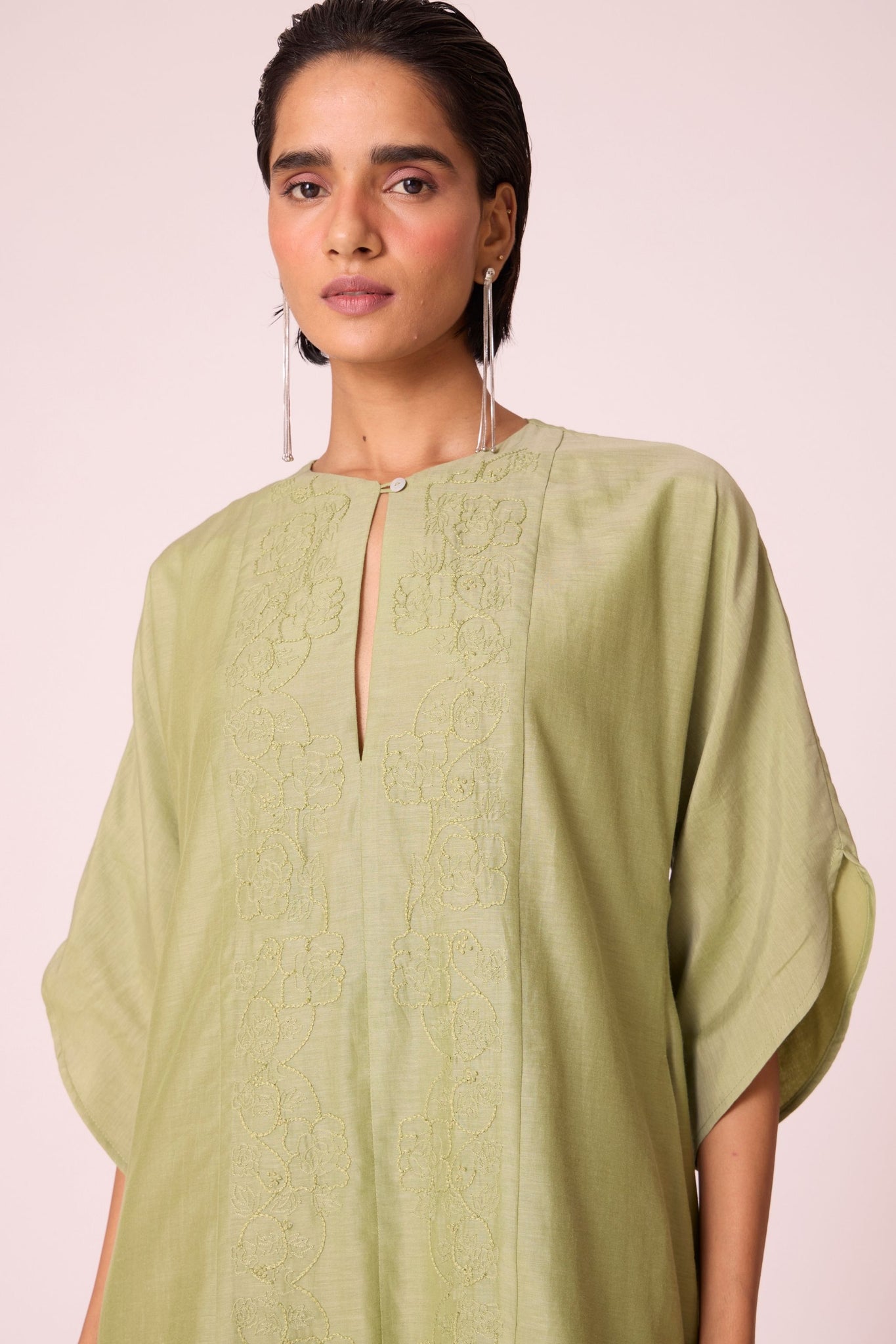Green silk-cotton dress with hand-embroidered keyhole neckline, drop sleeves, full lining, and in-seam pockets.