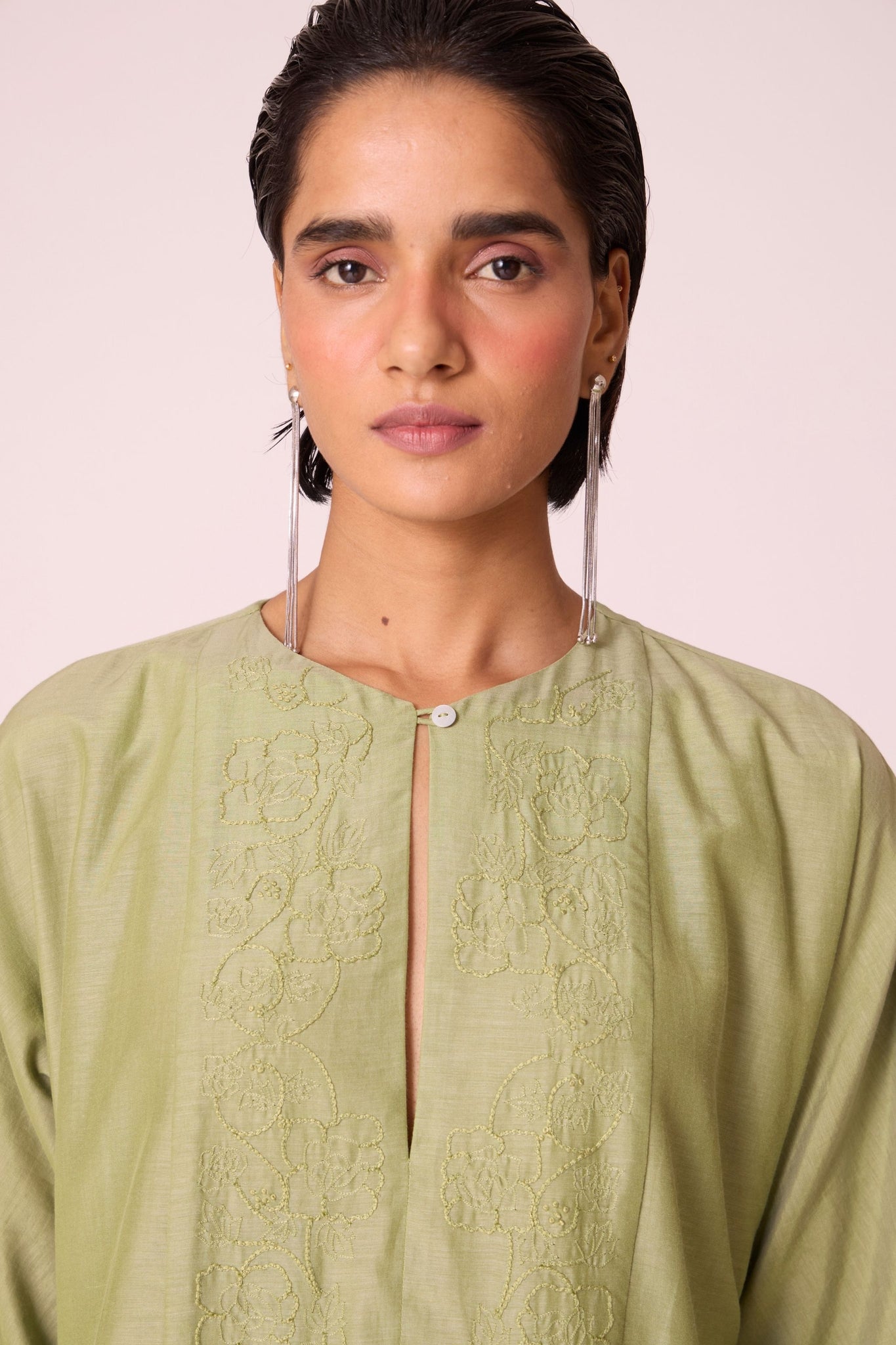 Green silk-cotton dress with hand-embroidered keyhole neckline, drop sleeves, full lining, and in-seam pockets.