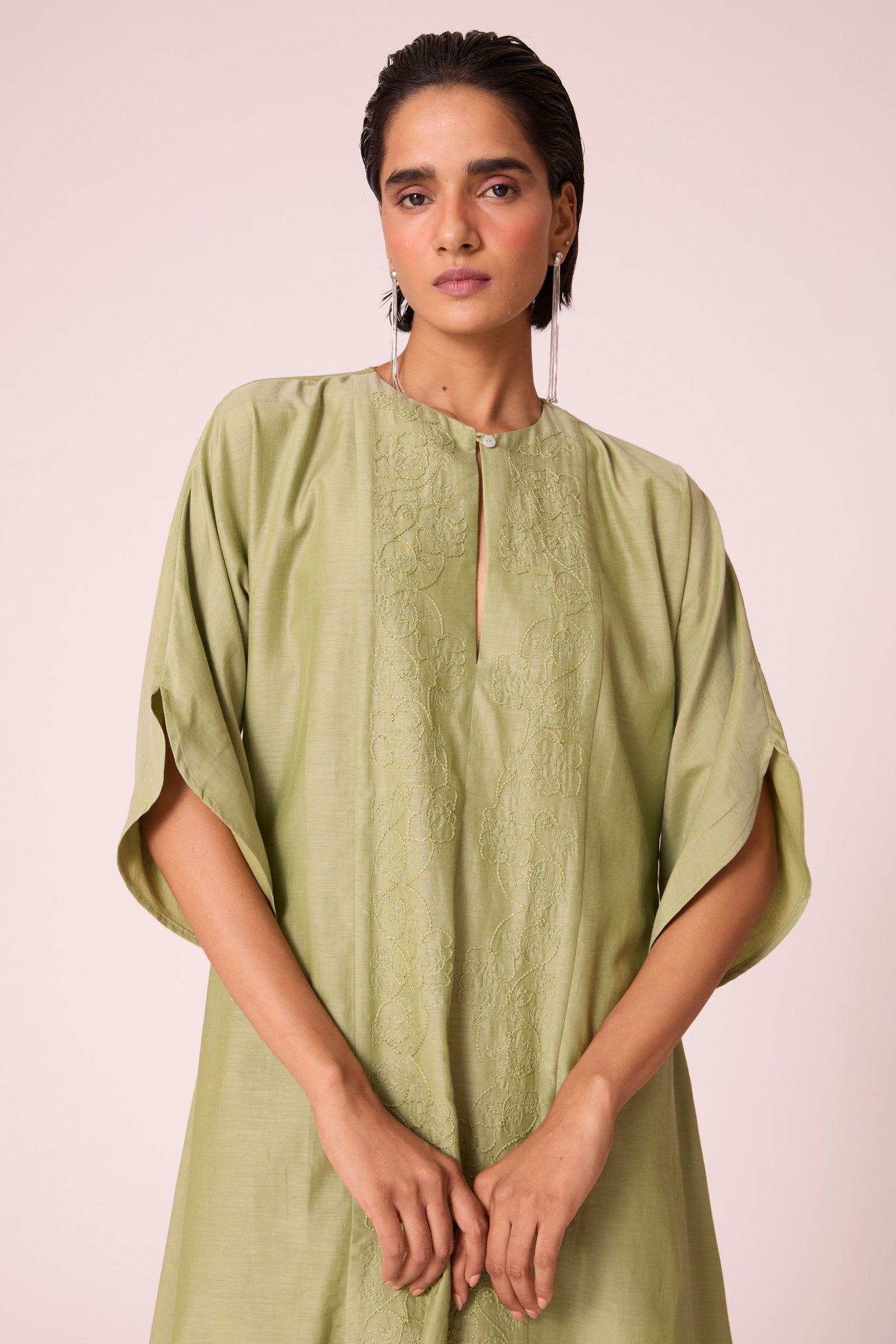 Green silk-cotton dress with hand-embroidered keyhole neckline, drop sleeves, full lining, and in-seam pockets.
