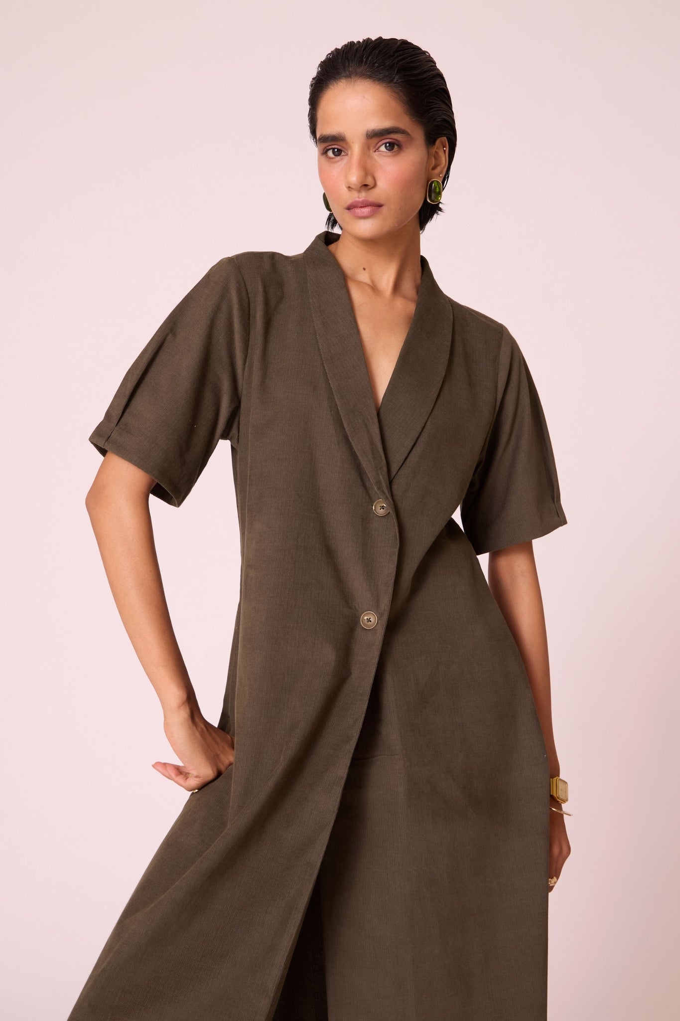 Olive needlecord structured wrap dress with double button fastening, shawl collar, sleeve box pleats, and in-seam pockets.