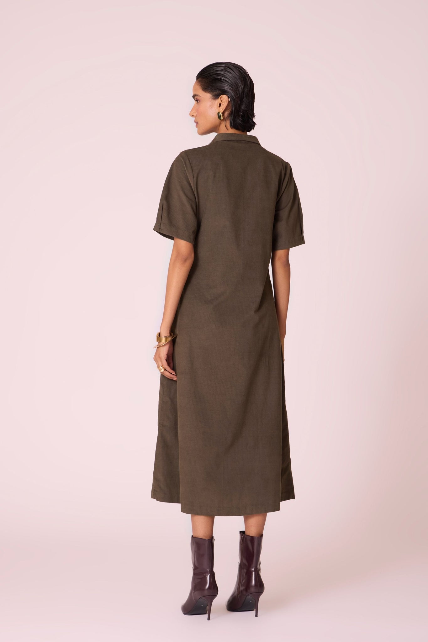 Olive needlecord structured wrap dress with double button fastening, shawl collar, sleeve box pleats, and in-seam pockets.