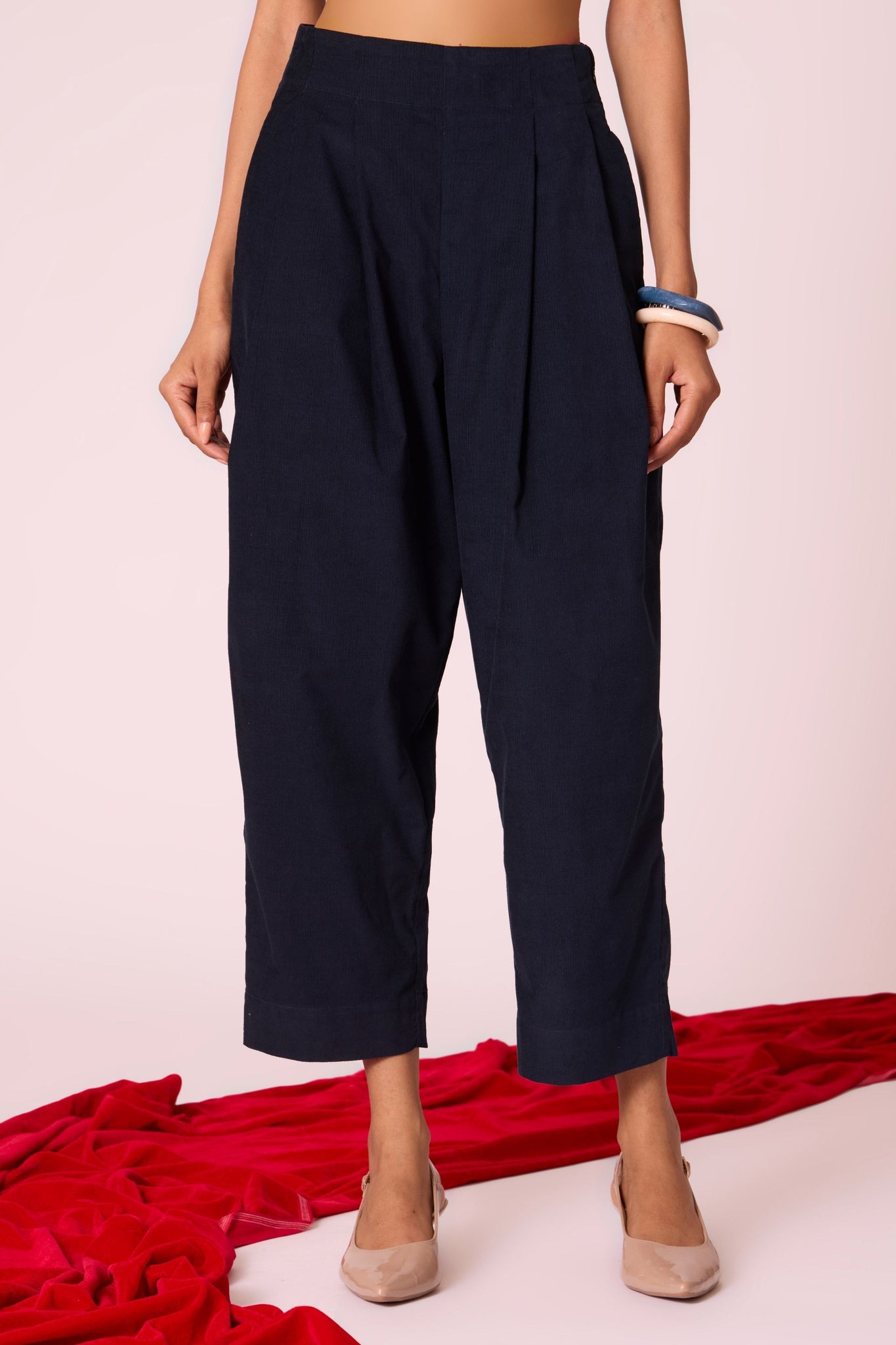 Navy needlecord high-rise cropped pants with four front pleats, side zip, and in-seam pockets.
