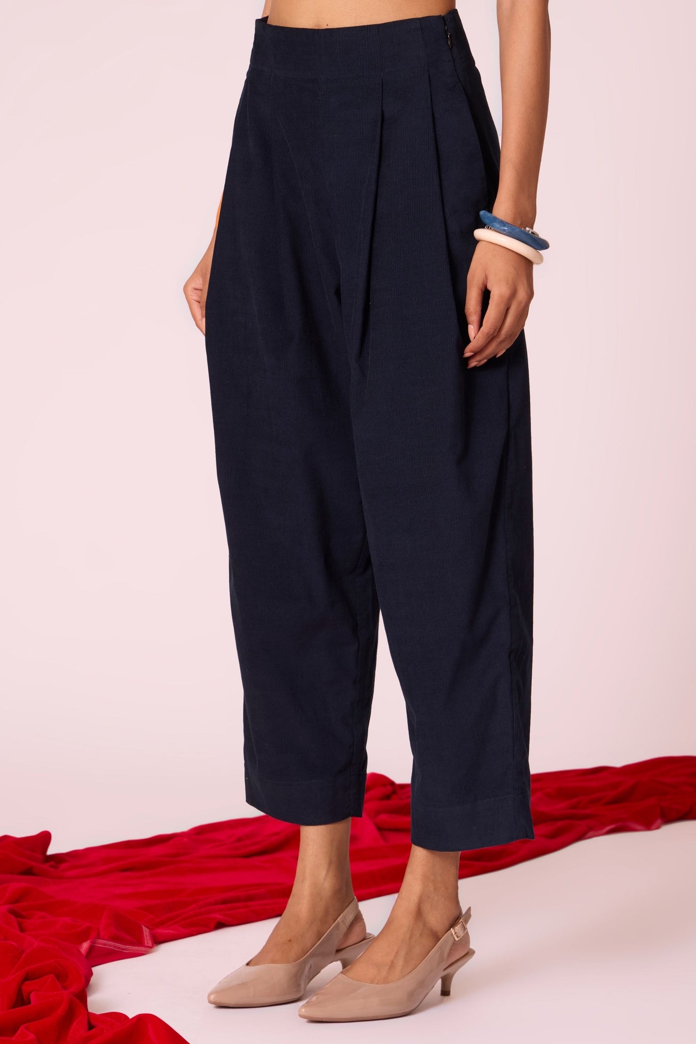 Navy needlecord high-rise cropped pants with four front pleats, side zip, and in-seam pockets.
