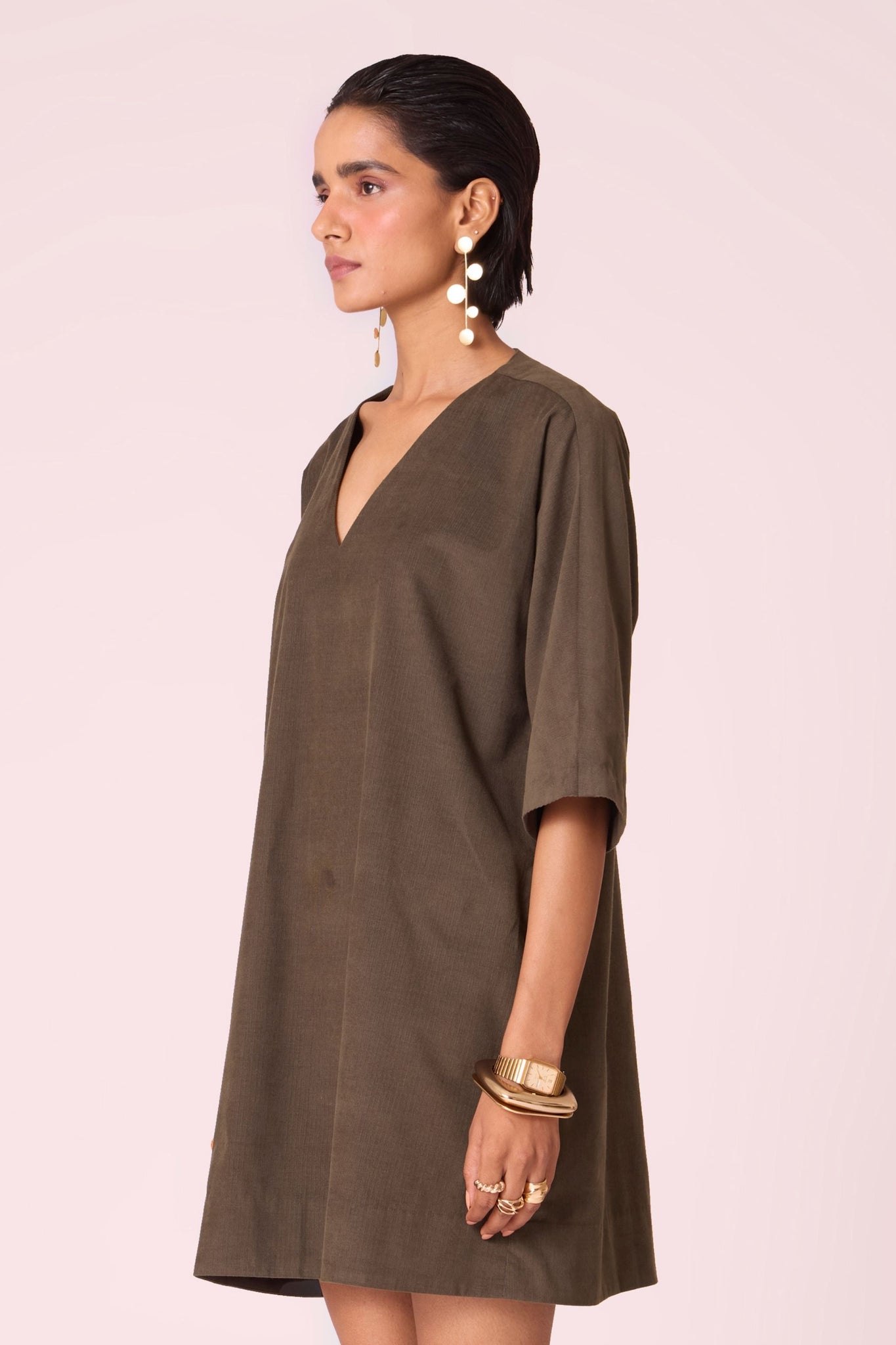 Olive needlecord shift dress with V-neckline, kimono-inspired sleeves, and in-seam pockets.