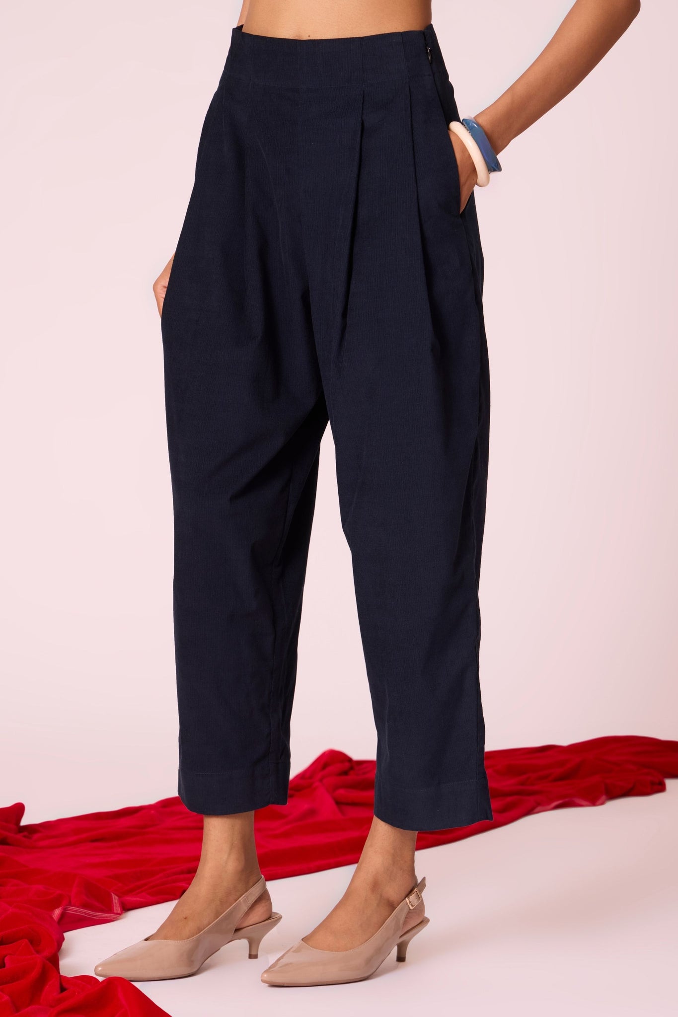 Navy needlecord high-rise cropped pants with four front pleats, side zip, and in-seam pockets.
