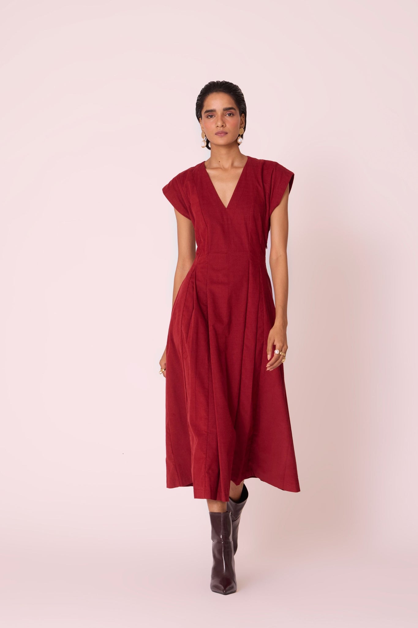 Rust needlecord panelled dress with box pleats, structured drop shoulder, V-neckline, side zip, and in-seam pockets.
