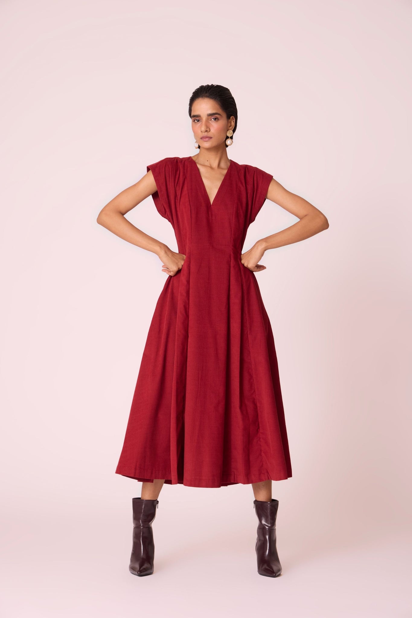 Rust needlecord panelled dress with box pleats, structured drop shoulder, V-neckline, side zip, and in-seam pockets.
