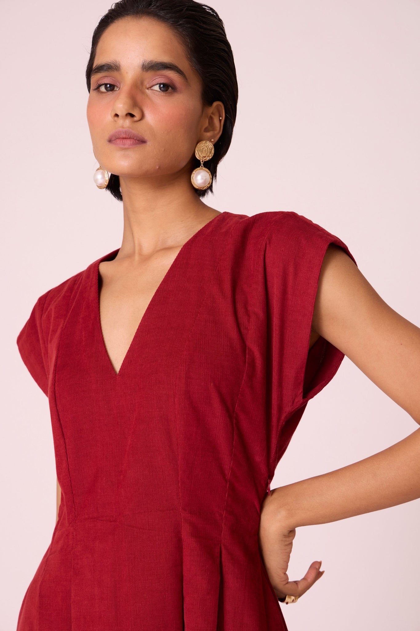 Rust needlecord panelled dress with box pleats, structured drop shoulder, V-neckline, side zip, and in-seam pockets.