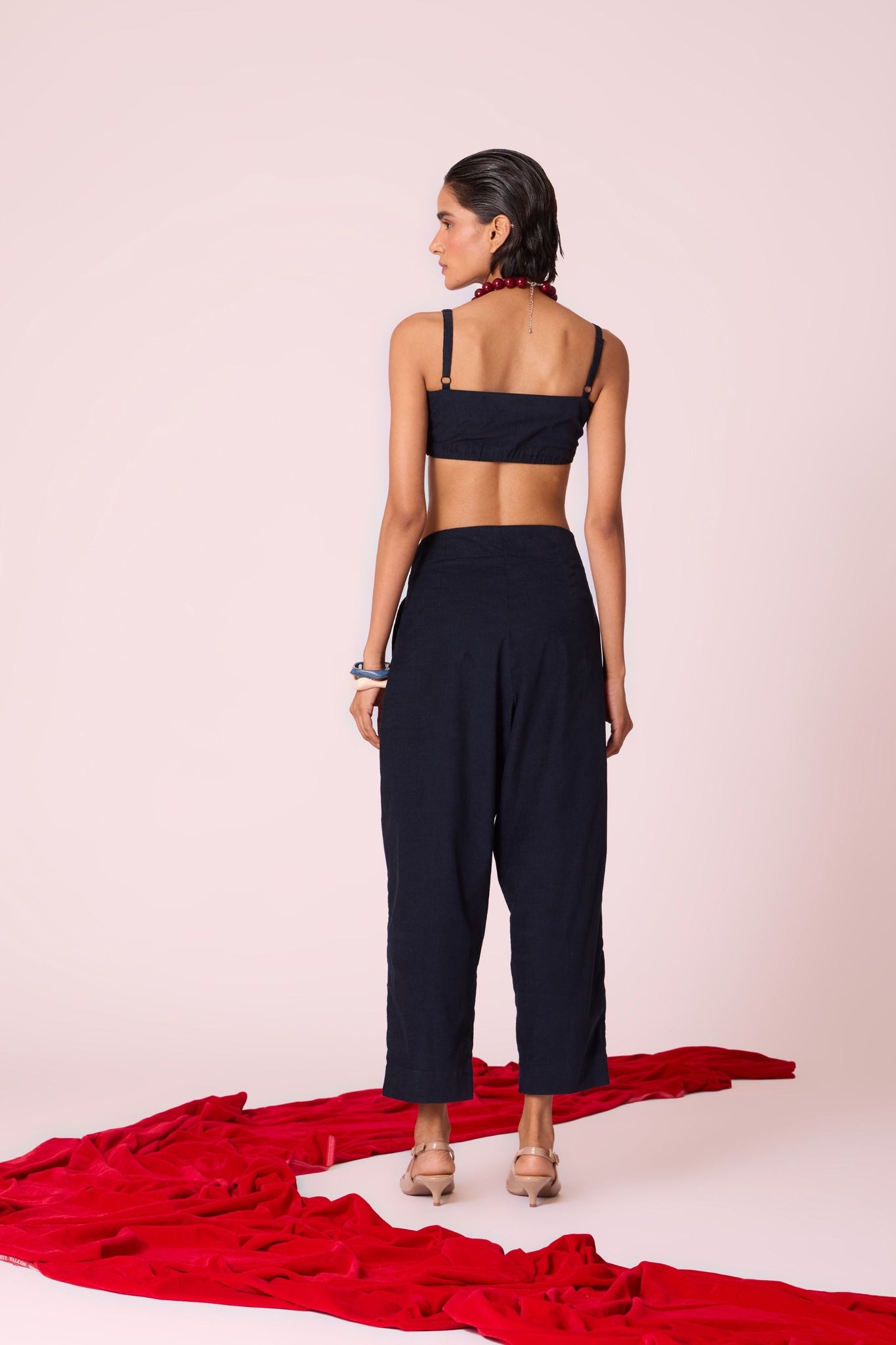 Navy needlecord high-rise cropped pants with four front pleats, side zip, and in-seam pockets.
