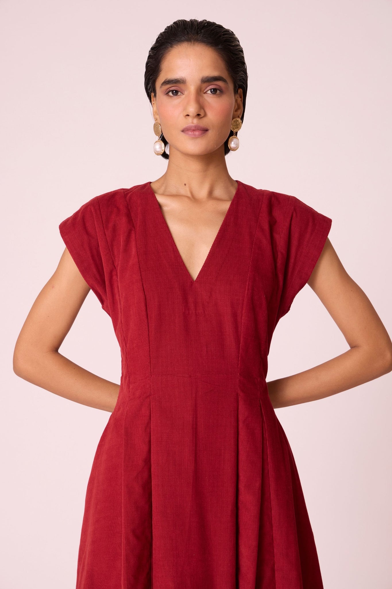 Rust needlecord panelled dress with box pleats, structured drop shoulder, V-neckline, side zip, and in-seam pockets.