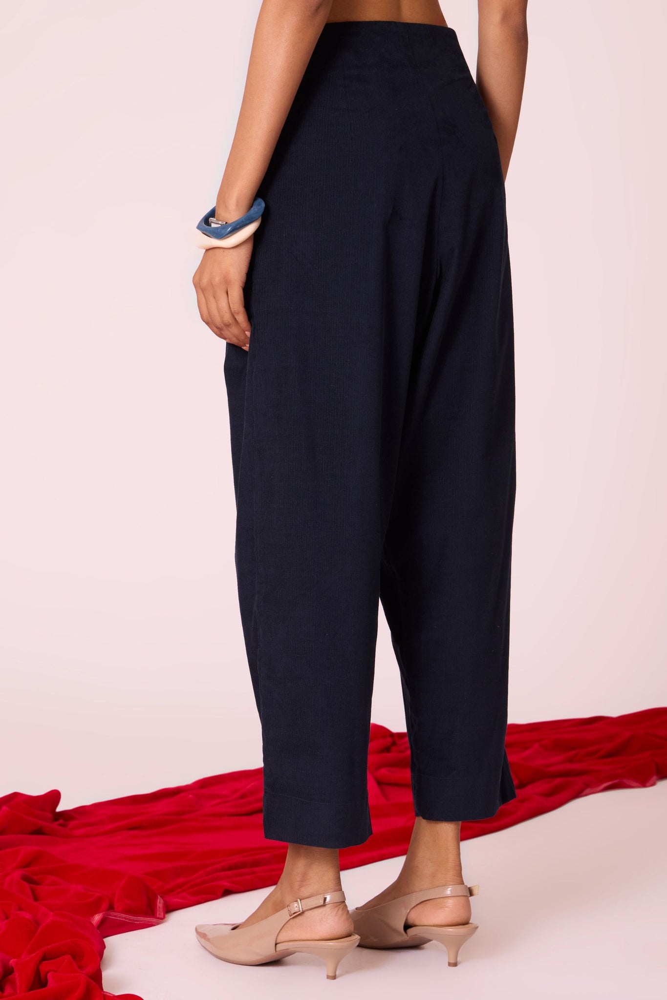 Navy needlecord high-rise cropped pants with four front pleats, side zip, and in-seam pockets.
