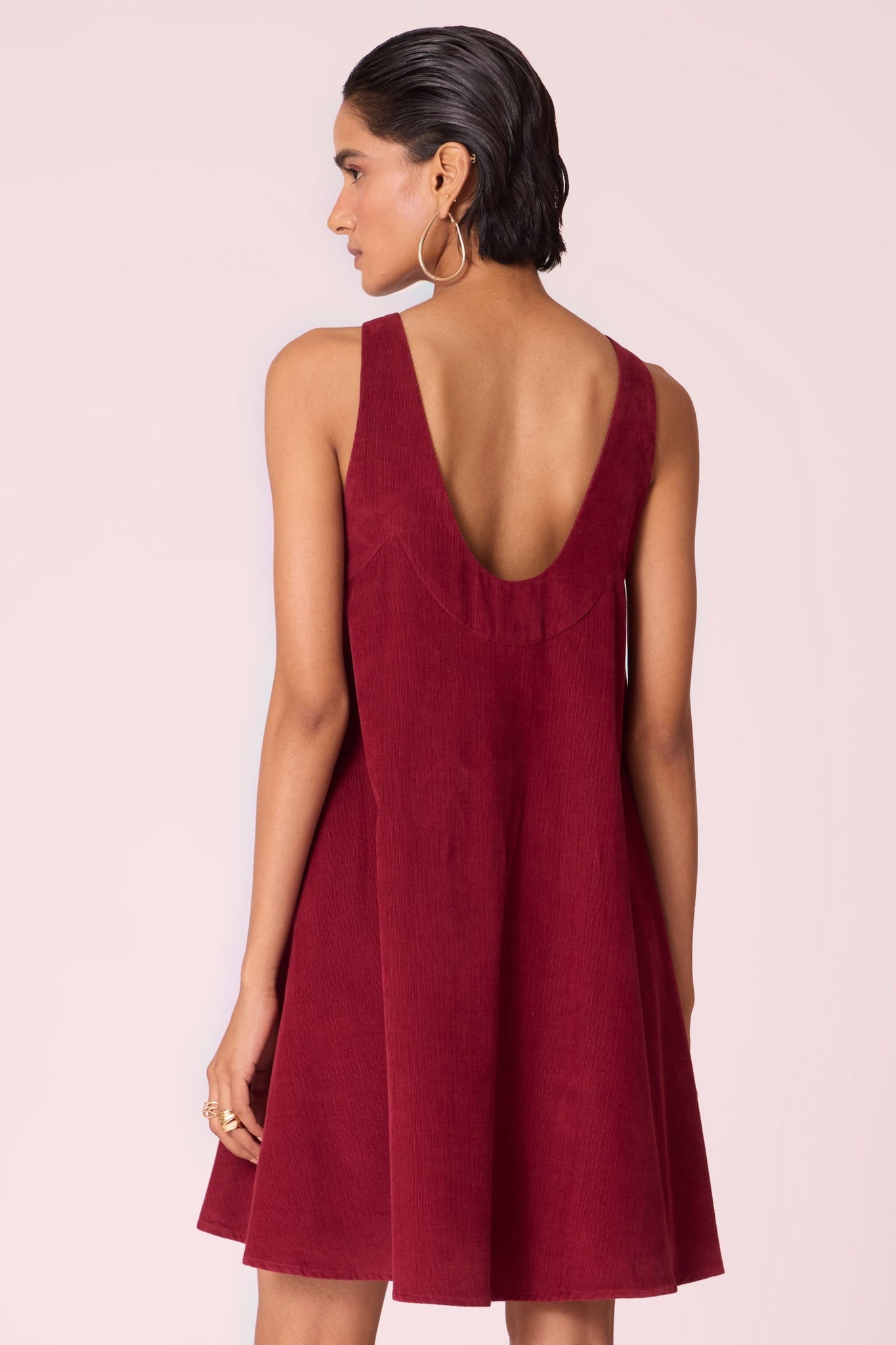 Cherry needlecord tent dress with incut shoulder, low scoop back, and in-seam pockets.
