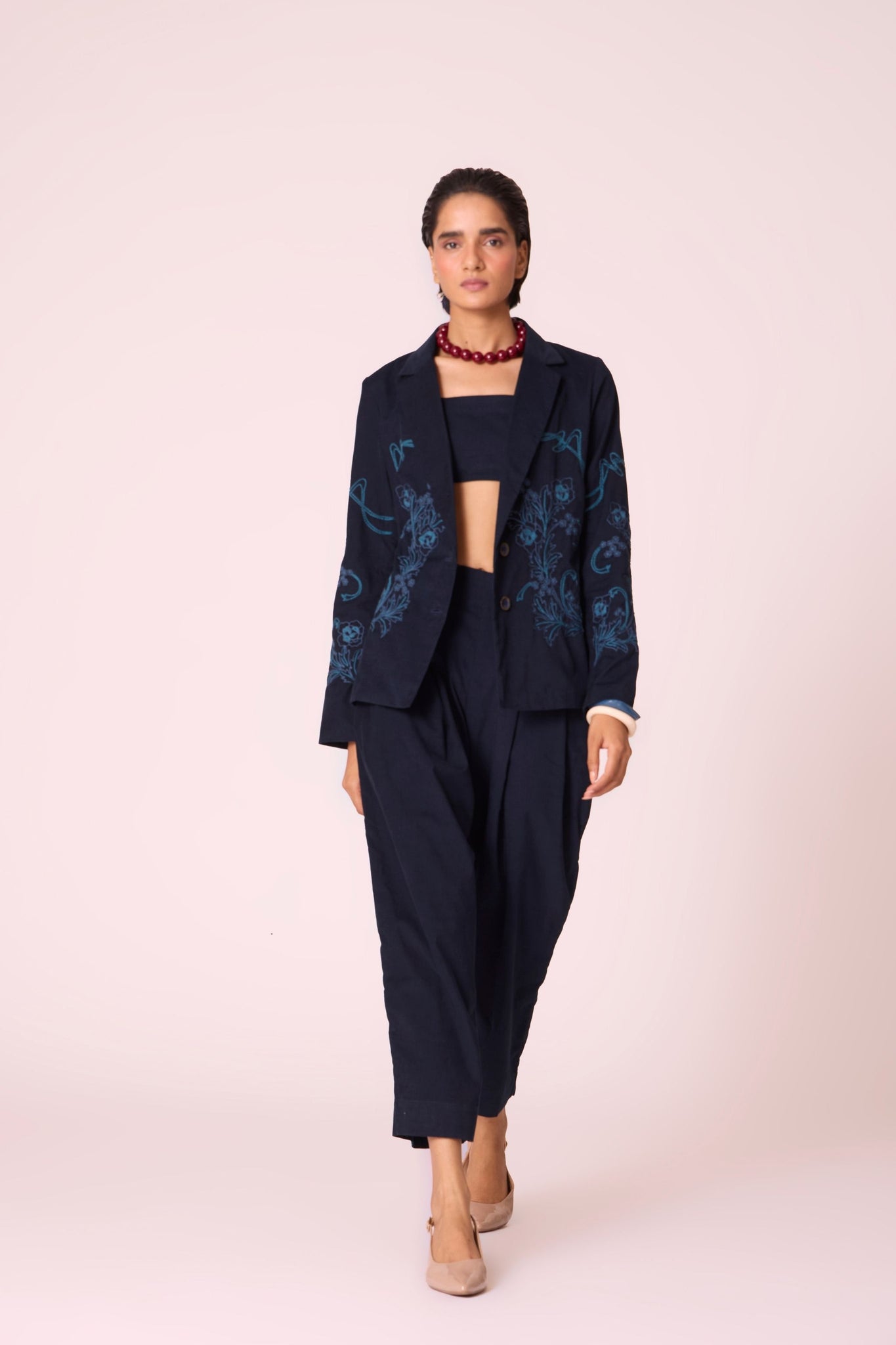 Navy needlecord high-rise cropped pants with four front pleats, side zip, and in-seam pockets.

