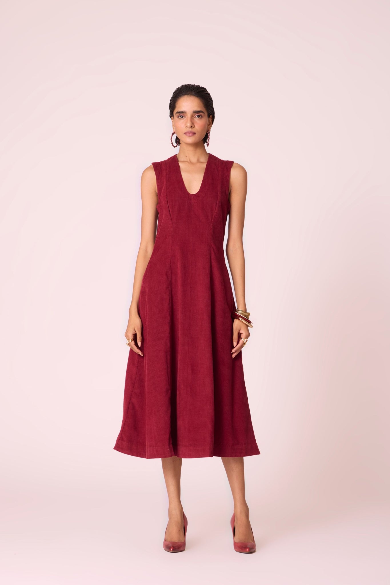 Cherry needlecord fit-and-flare midi dress with soft V-neckline, panel detailing, side zip, and in-seam pockets.

