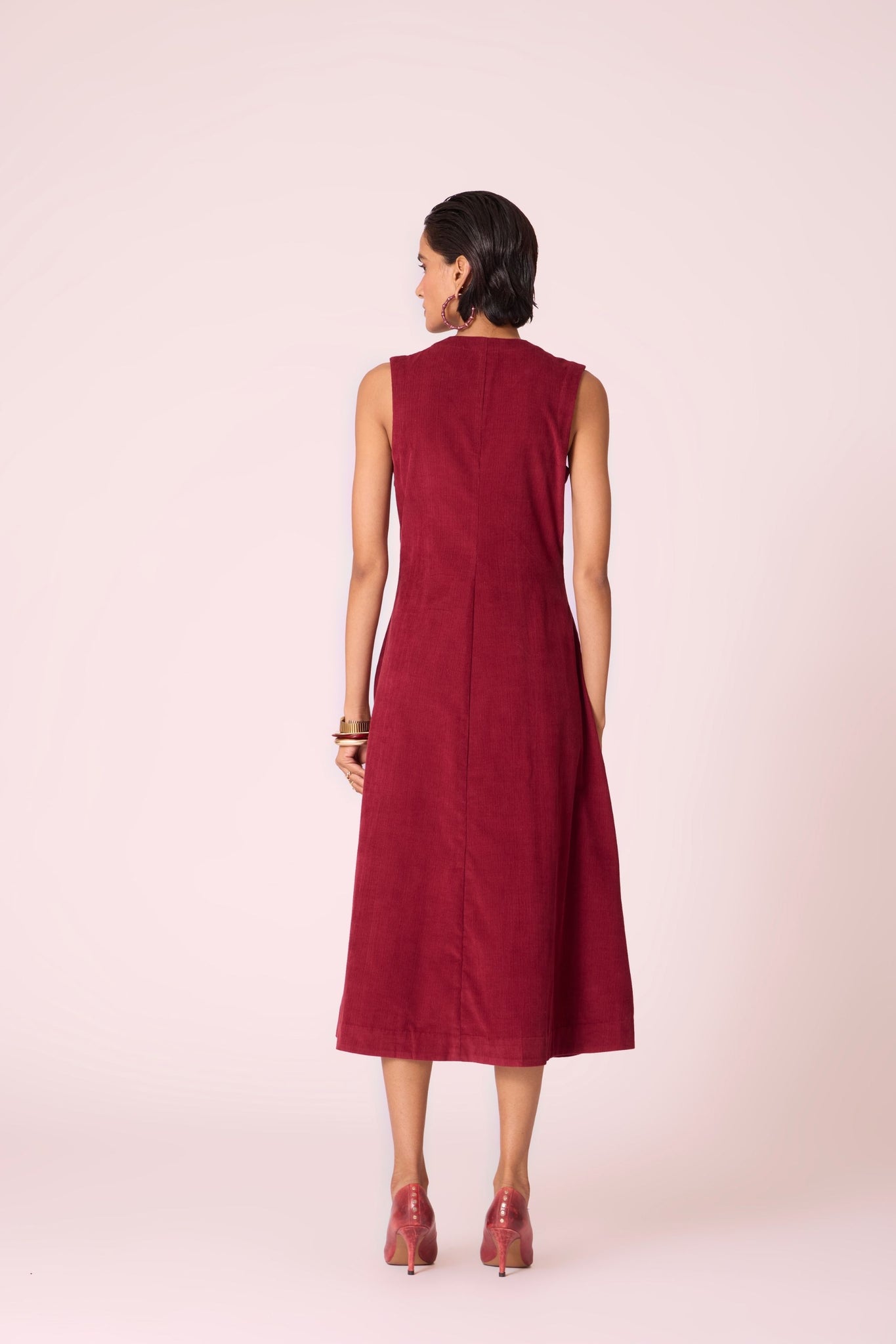 Cherry needlecord fit-and-flare midi dress with soft V-neckline, panel detailing, side zip, and in-seam pockets.
