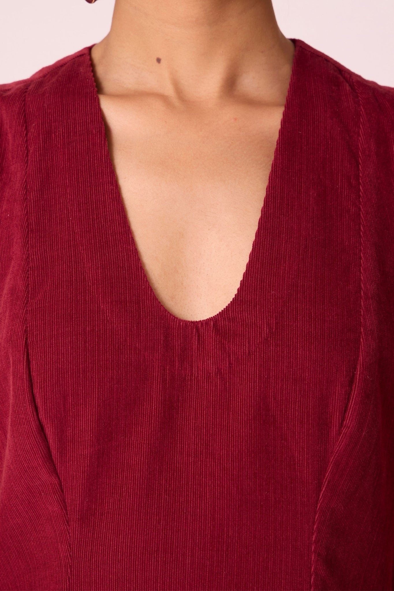 Cherry needlecord fit-and-flare midi dress with soft V-neckline, panel detailing, side zip, and in-seam pockets.
