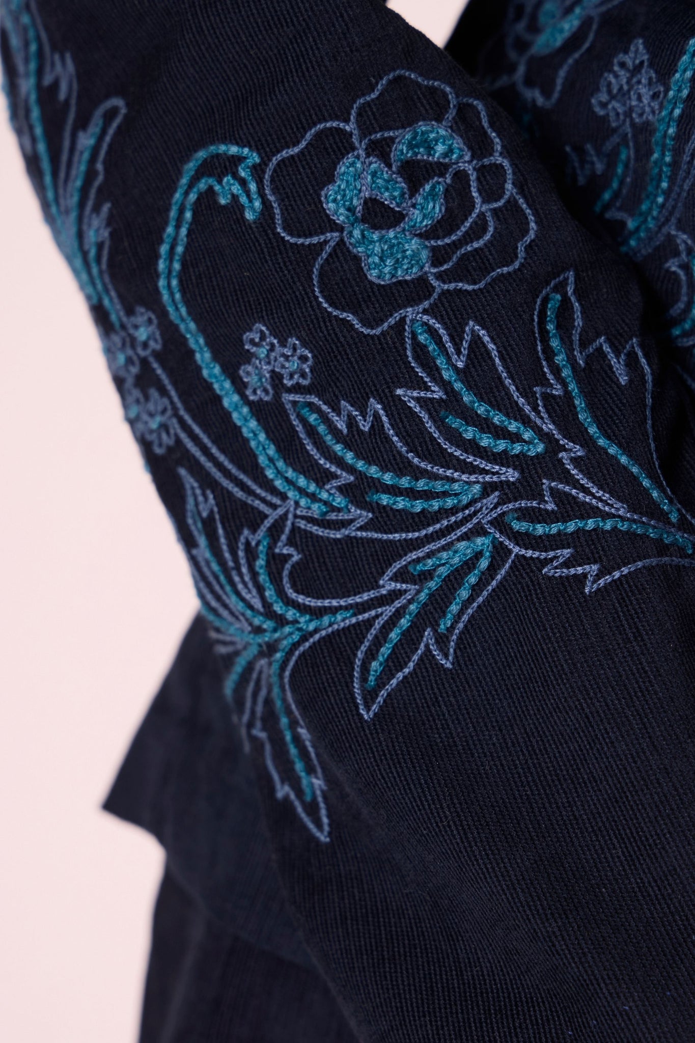 Navy needlecord slim-fit jacket with hand-embroidered waist and sleeves, notch collar, and full-length sleeves.
