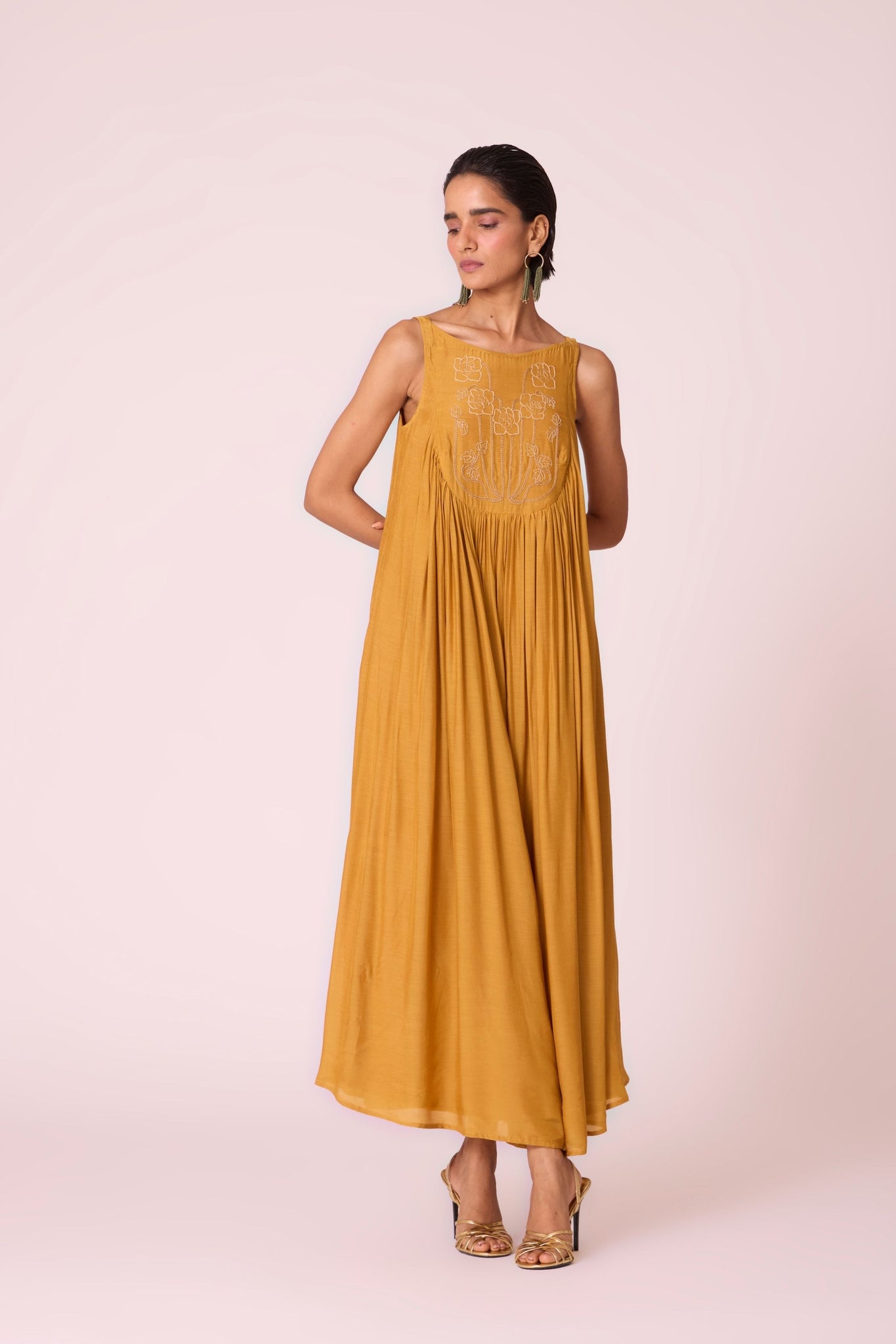 Yellow cupro maxi dress with hand-embroidered yoke, low scoop back with elastic strap, full lining, and light waist gathers.
