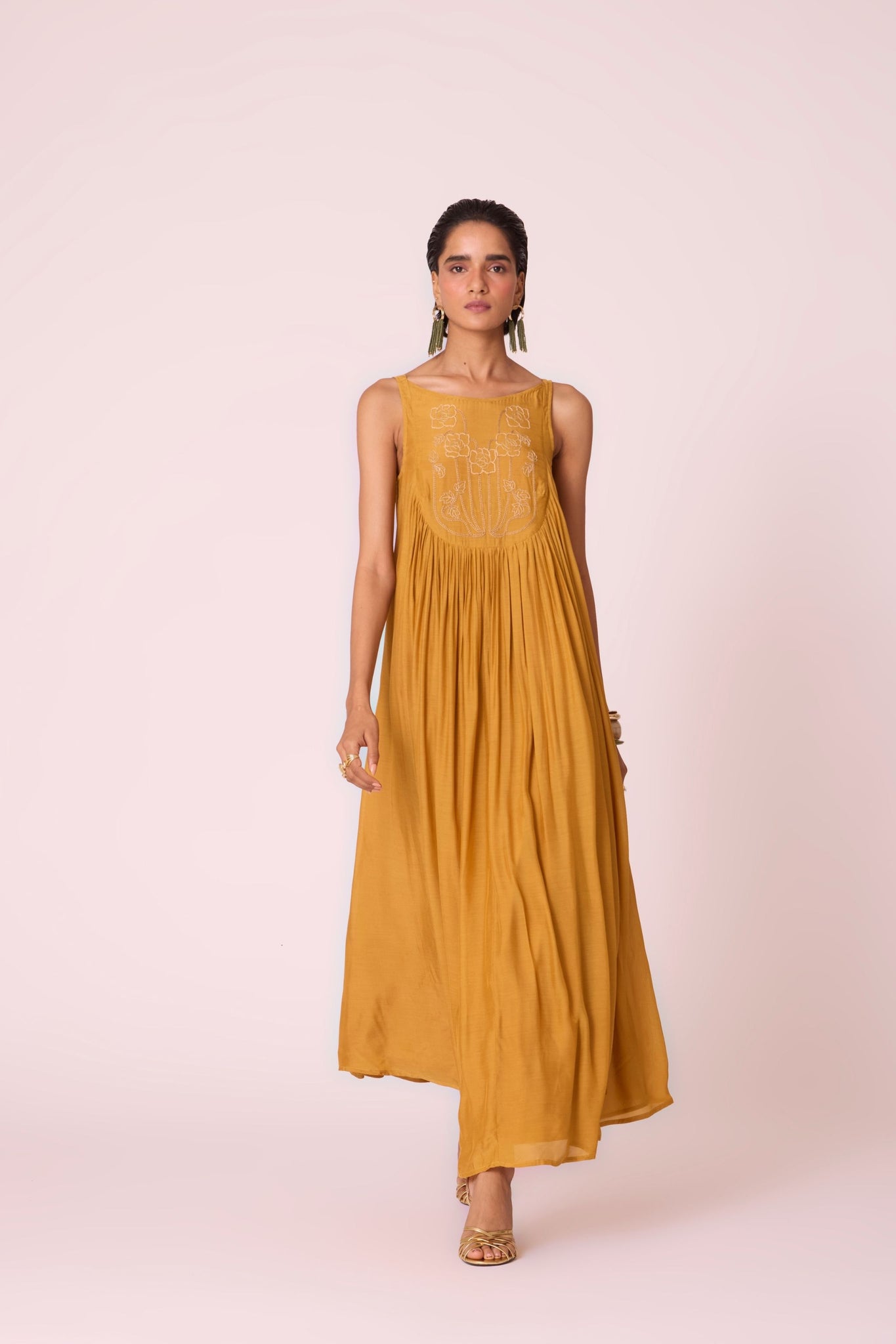 Yellow cupro maxi dress with hand-embroidered yoke, low scoop back with elastic strap, full lining, and light waist gathers.
