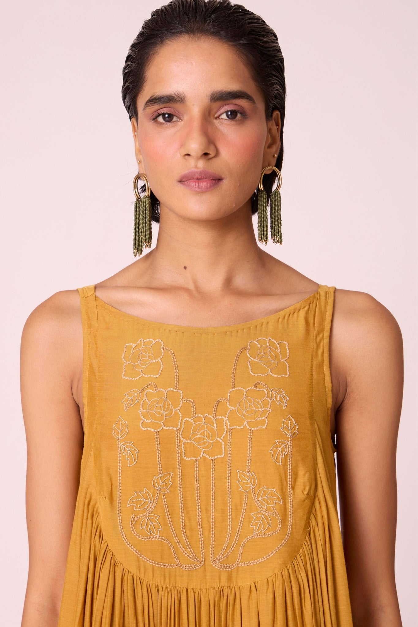 Yellow cupro maxi dress with hand-embroidered yoke, low scoop back with elastic strap, full lining, and light waist gathers.
