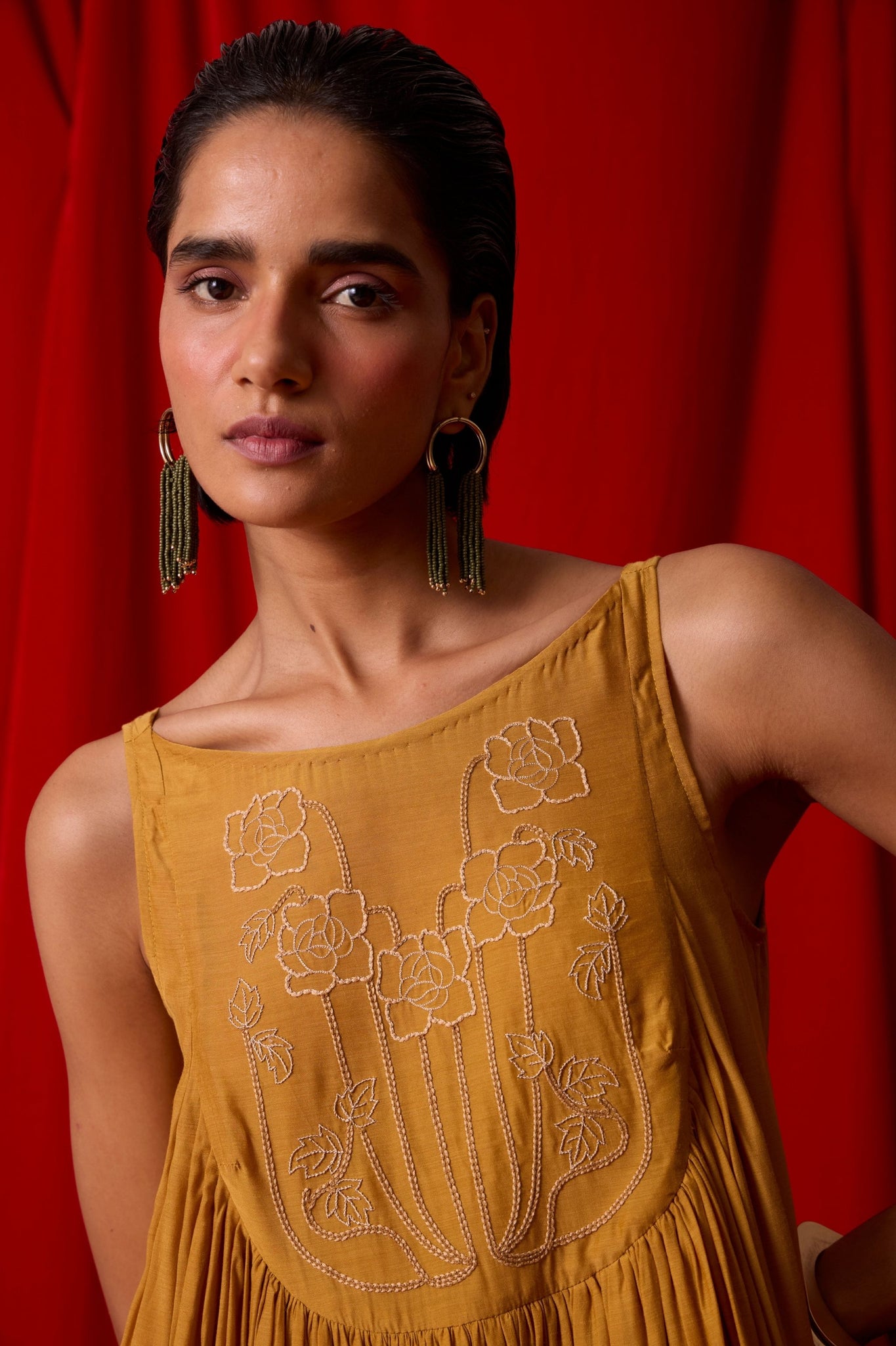 Yellow cupro maxi dress with hand-embroidered yoke, low scoop back with elastic strap, full lining, and light waist gathers.
