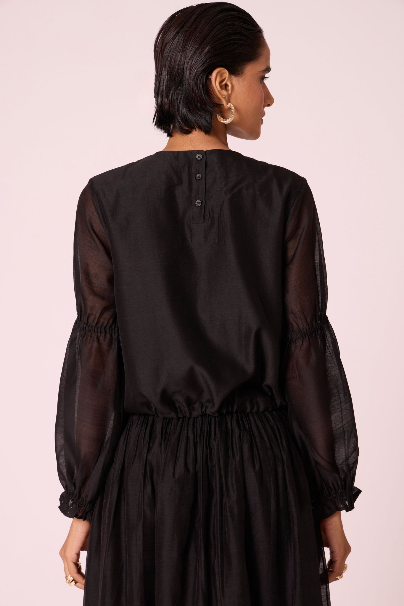 Black handwoven Chanderi top with drawstring waist, back button fastening, and elasticated sleeve details.