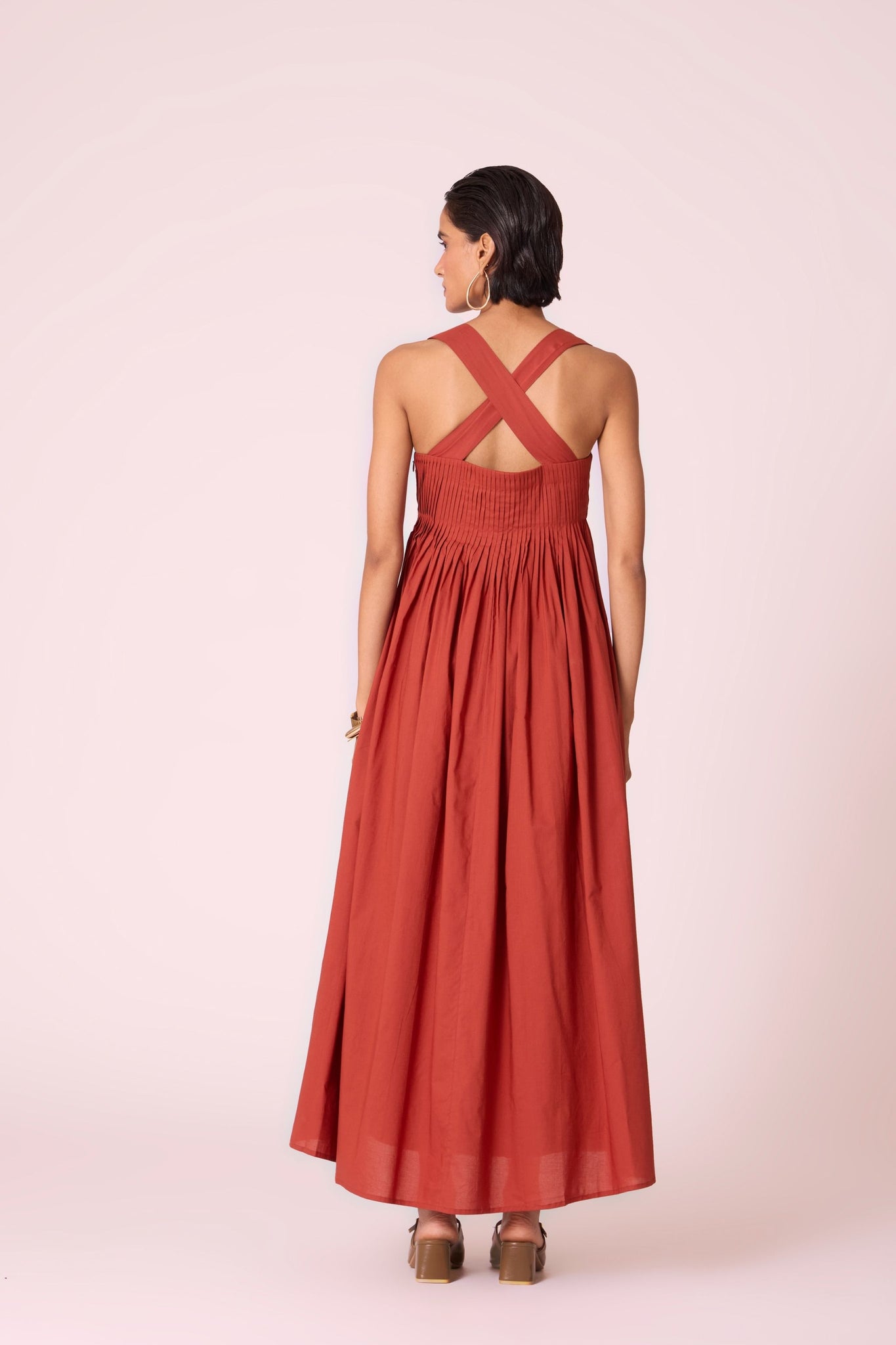 Rust pleated dress in organic cotton voile with a square neckline, thick straps, and a fully lined flared silhouette.
