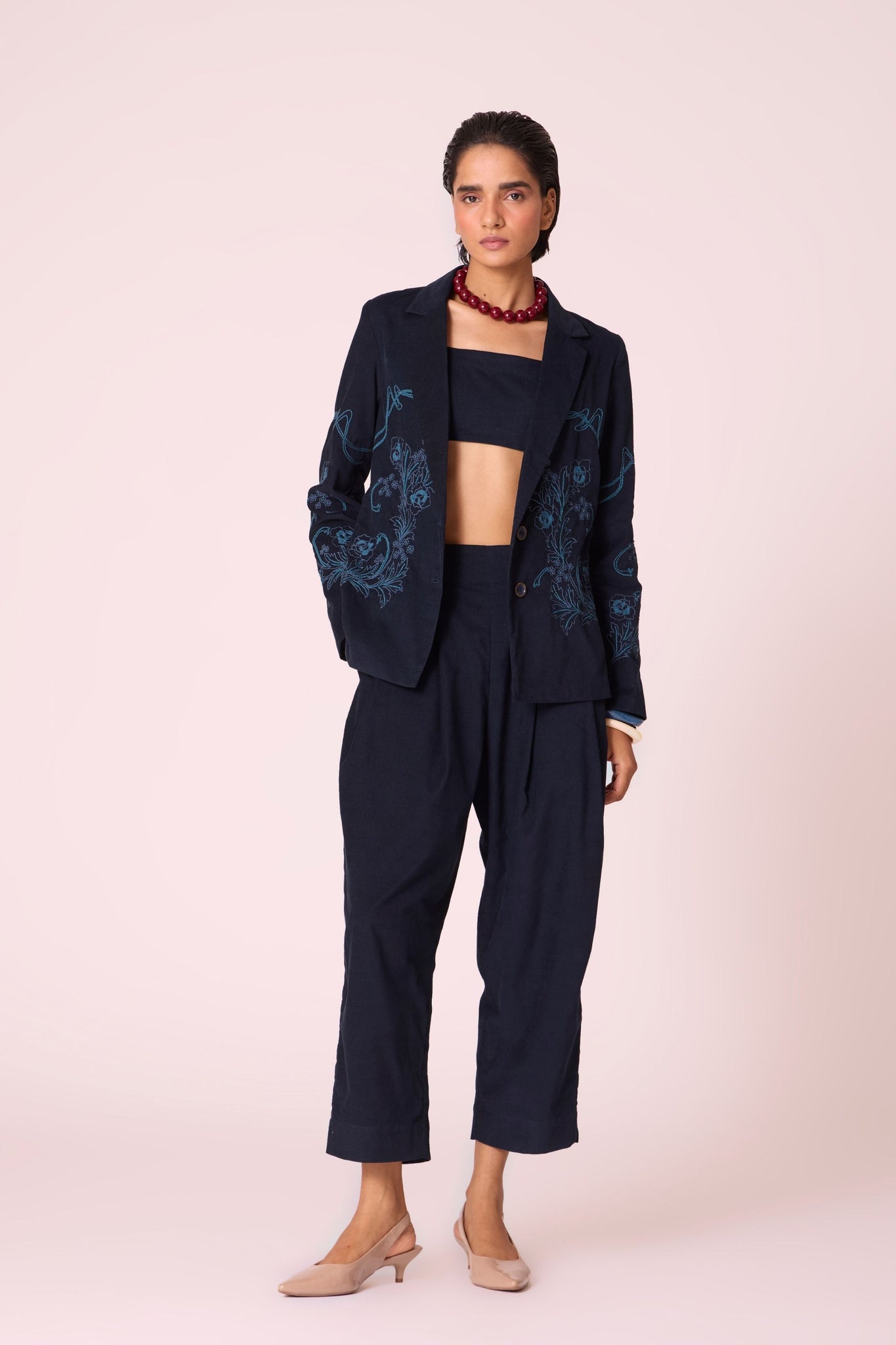 Navy needlecord slim-fit jacket with hand-embroidered waist and sleeves, notch collar, and full-length sleeves.
