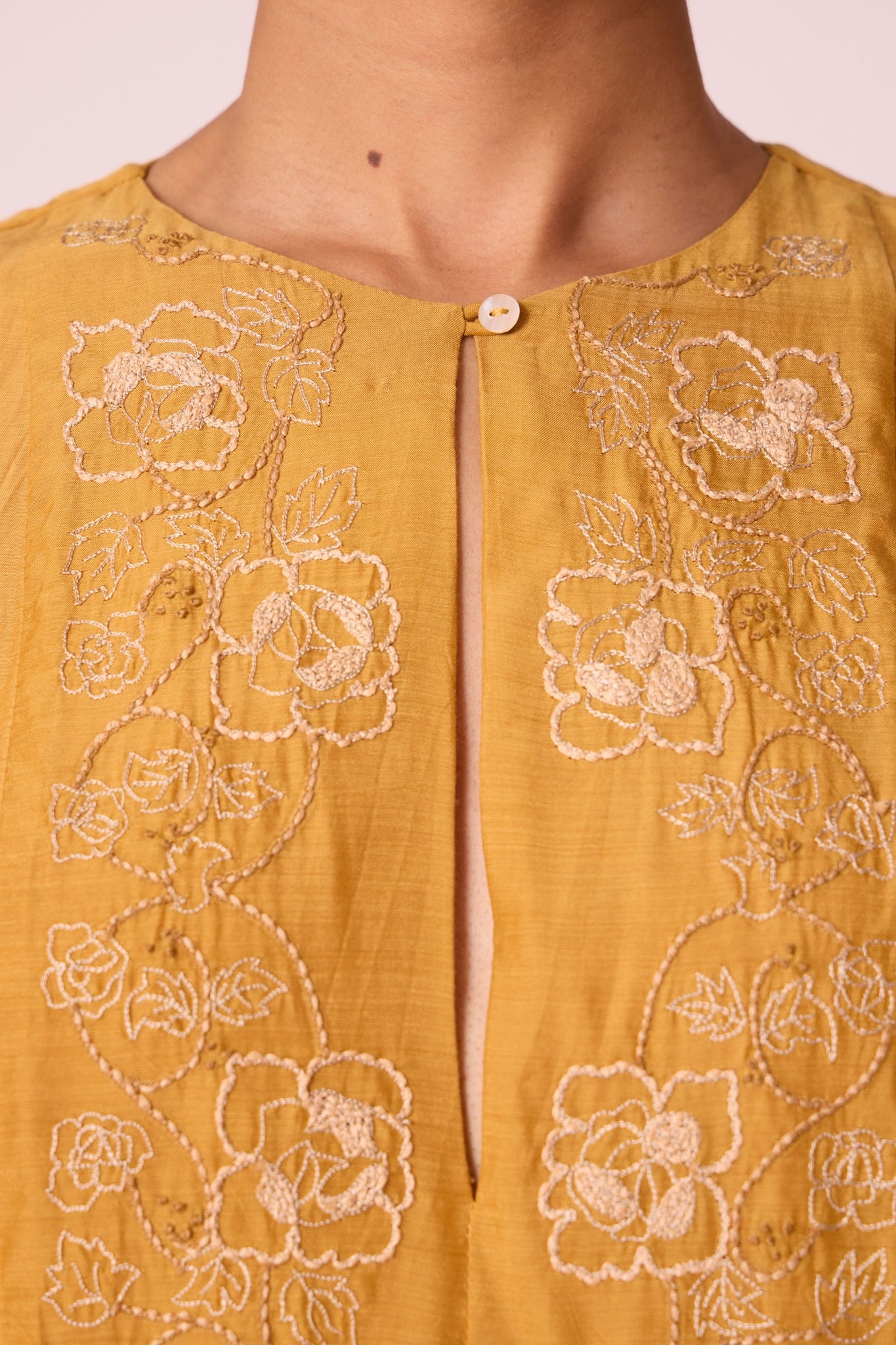 Yellow cupro dress with hand-embroidered keyhole neckline, drop sleeves, full lining, and in-seam pockets.
